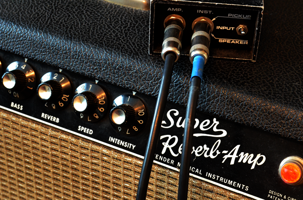 In this picture the output from a guitar is connected to the instrument-level input on a direct box. The thru connection, marked ‘amp’ on this model, allows the guitar signal to be connected to a vintage amp while the raw guitar signal is simultaneously sent to a mixing console or recording device via the XLR mic output on the DI box’s rear panel. 