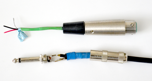 A balanced XLR cable (above) showing its two signal wires and its ground (with a foil shield) compared with a typical 2-conductor TS guitar cable (below).